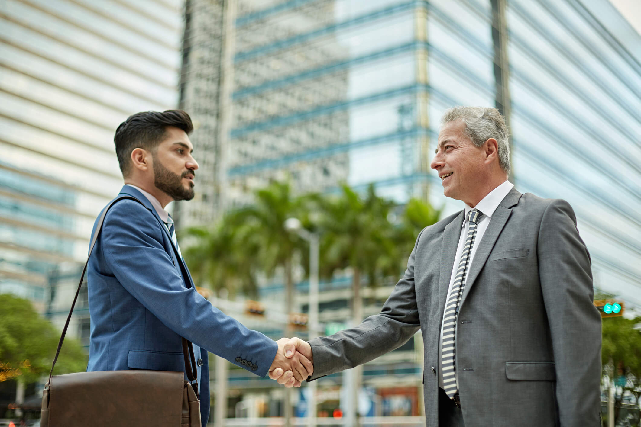Businessmen shaking hands outdoors